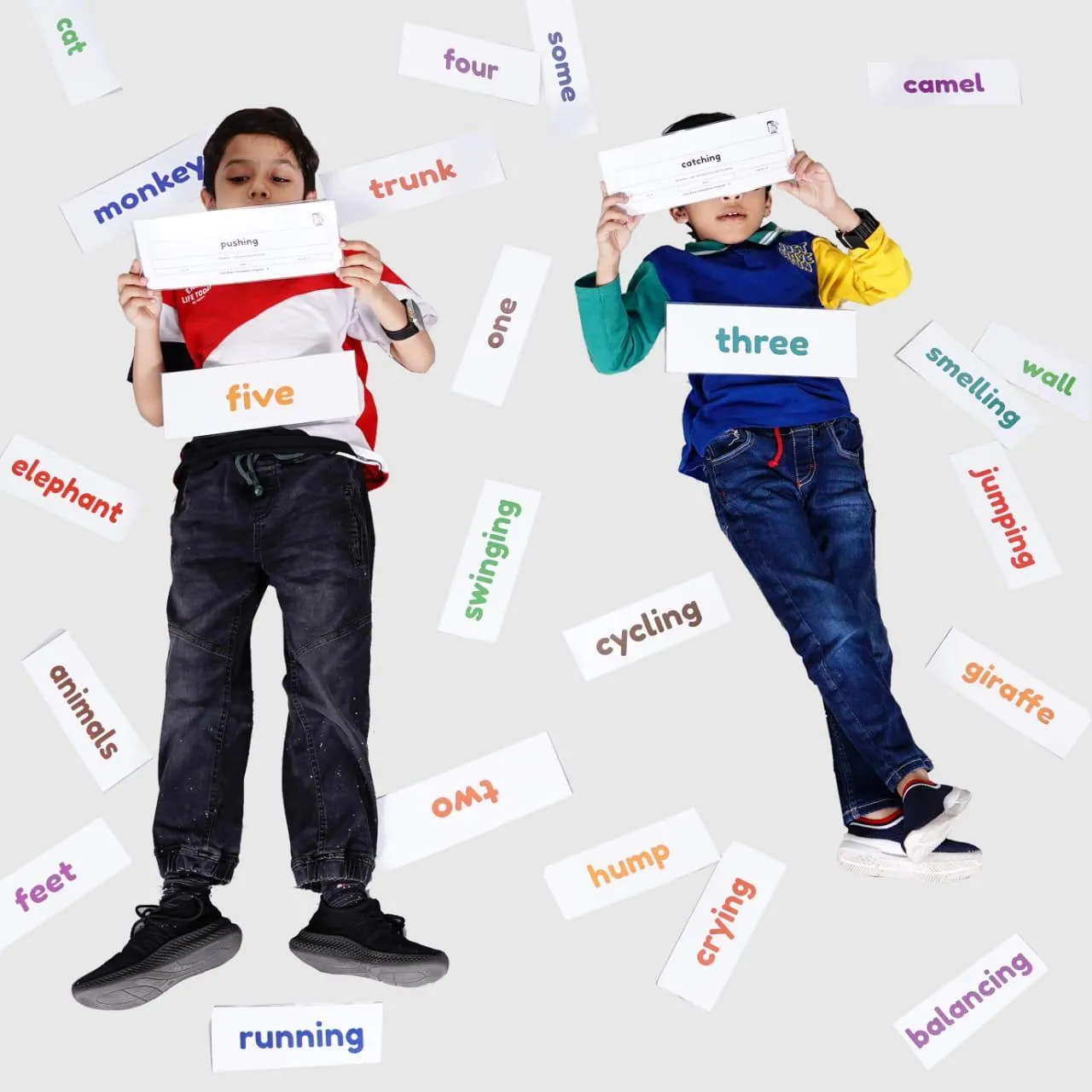 Two boys holding word flash cards for early reading