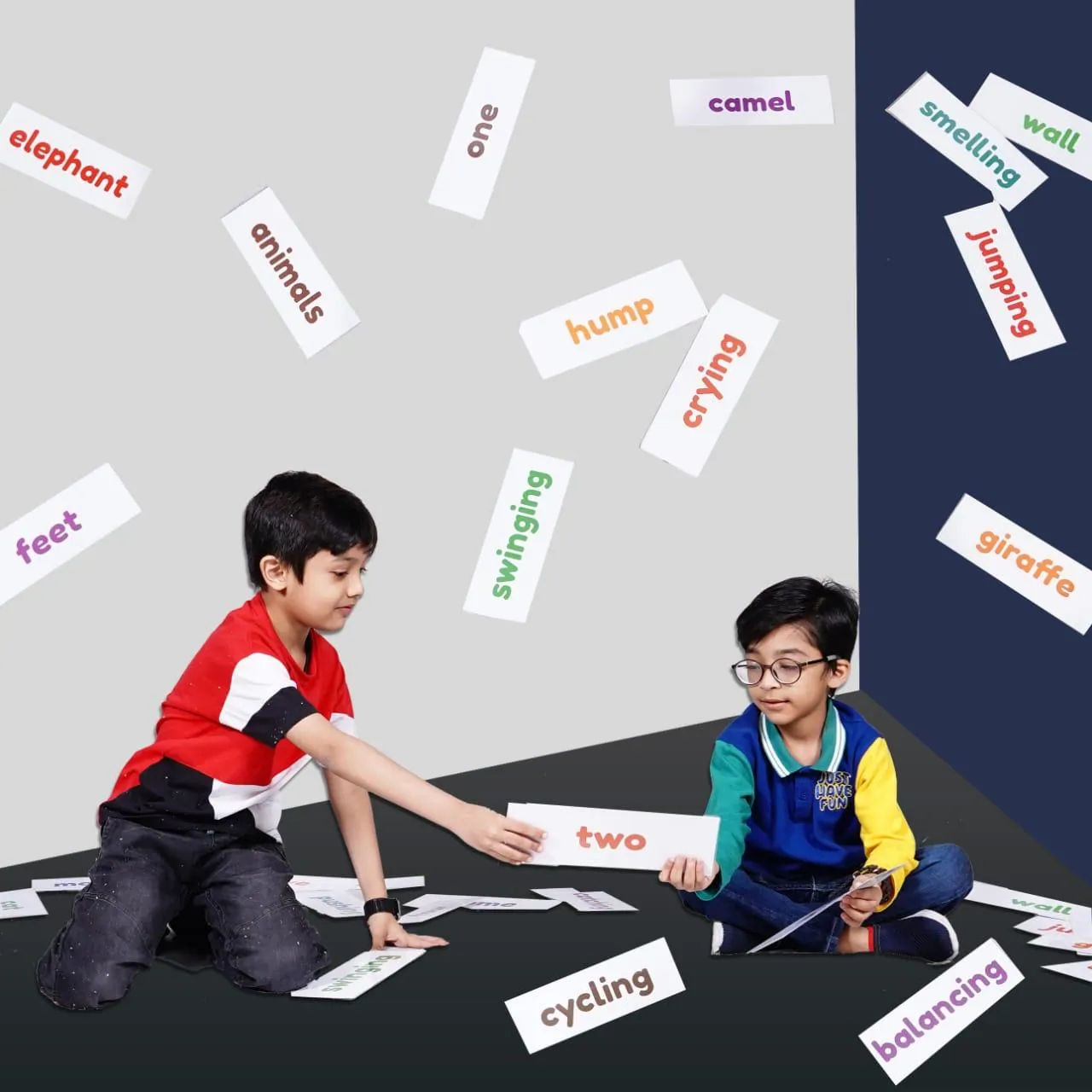 Two boys playing a word card game on the floor